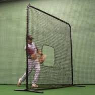 Softball pitcher using softball pitching screen indoors